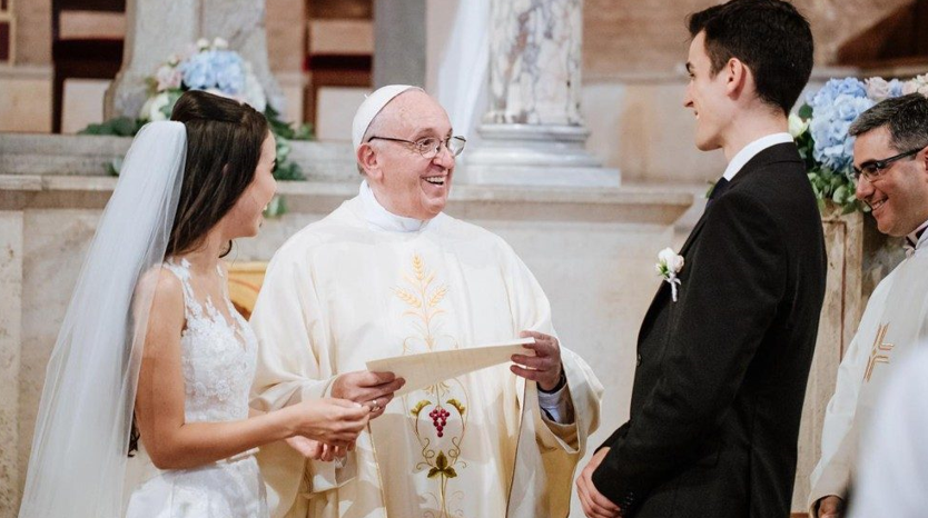 El Papa Francisco entregando un documento a una pareja joven durante una ceremonia de boda en una iglesia